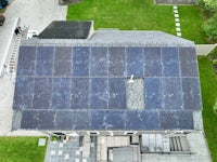 an aerial view of a house with solar panels on the roof